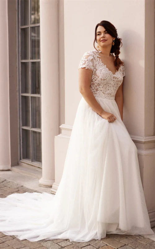 Vestido de novia informal de corte A con escote barco, encaje y cola corta con fruncido.