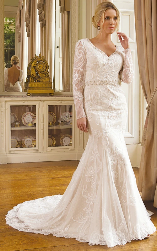 Vestido de novia largo de encaje con cuello en V, mangas largas y pedrería, bordados y adornos en la cintura.