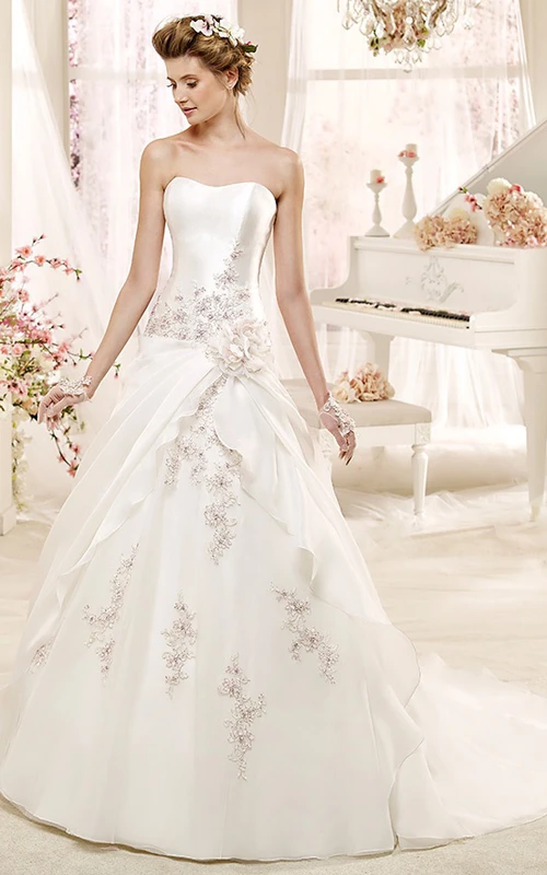 Robe de mariée bustier Angel, coupe trapèze, ornée de perles, avec superposition asymétrique et laçage au dos.