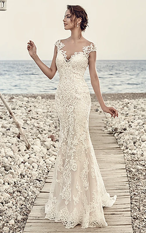 Vestido de novia de encaje largo hasta el suelo con mangas cortas, escote en V, apliques y efecto ilusión.