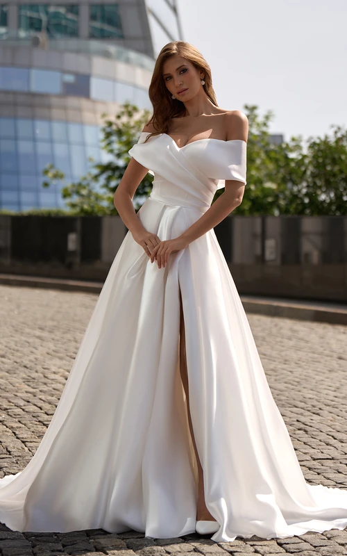 Robe de mariée en satin à épaules dénudées, coupe empire, fente croisée sur le devant et bretelles croisées.