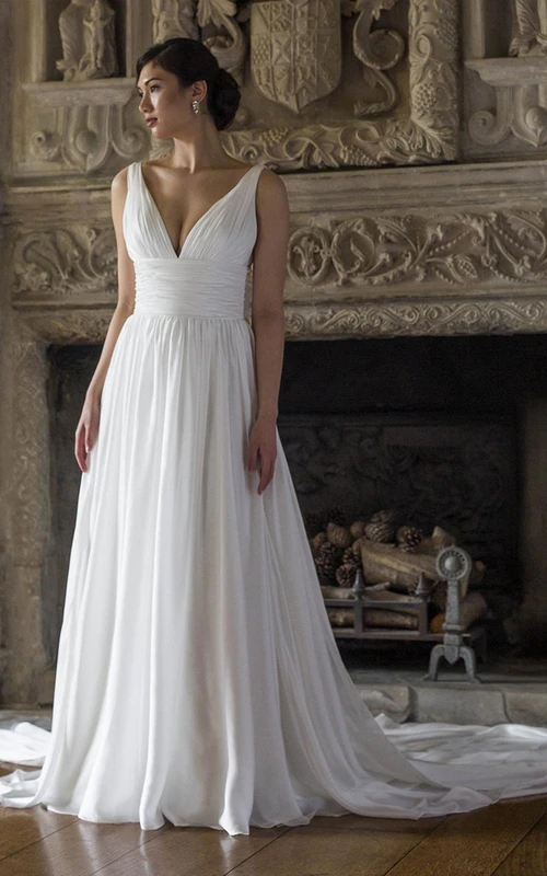 Robe de mariée longue en mousseline de soie, coupe trapèze, col en V, froncée, sans manches, plissée et ornée de fleurs.