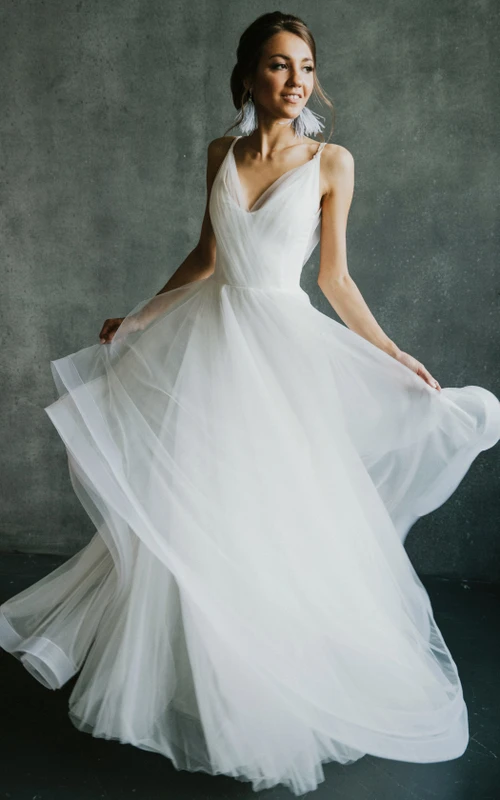Fließendes, ärmelloses Brautkleid aus Tüll mit gekreuzten Trägern im Empire-Stil, tiefem V-Ausschnitt und drapiertem Rock