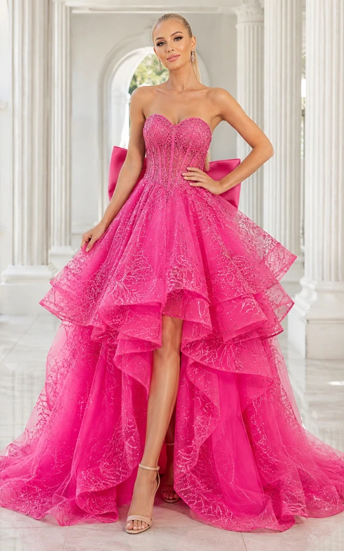 Vestido de fiesta fucsia sin tirantes con lazo de encaje, volantes en cascada, corte A asimétrico y cola de corte clásico.