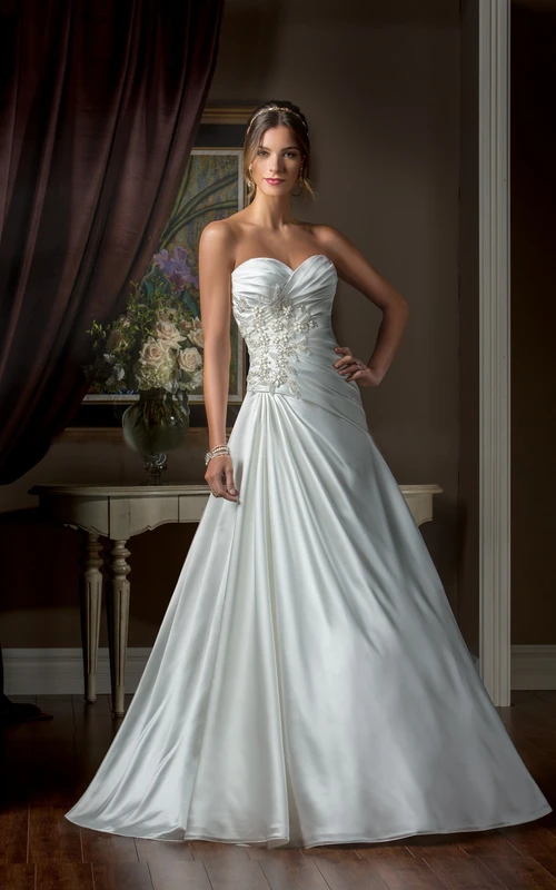 Vestido de novia de corte A con escote corazón, fruncido asimétrico y abalorios.