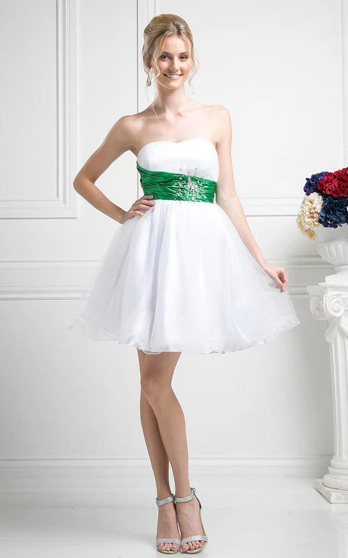 Vestido corto multicolor de corte A, sin tirantes, sin espalda y con joyas en la cintura.