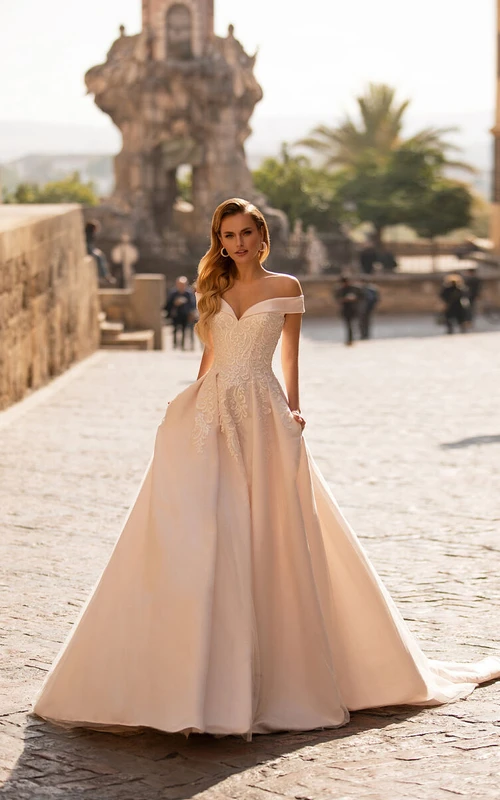 Robe de mariée en satin, épaules dénudées, coupe empire et dentelle.
