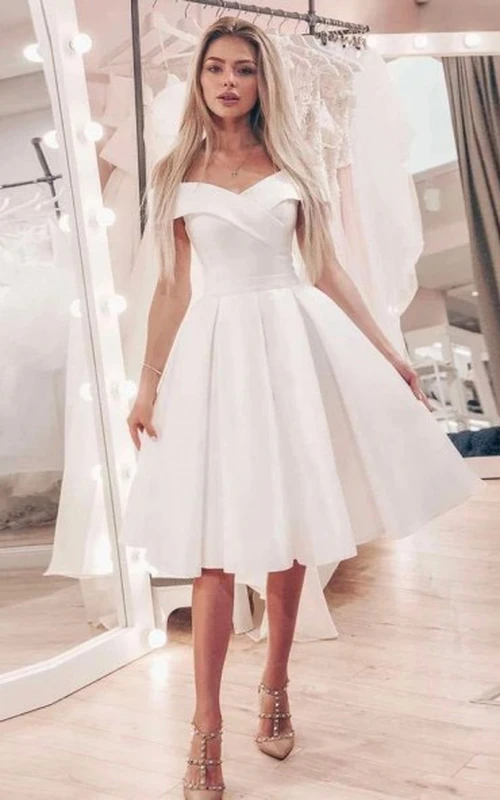 Vestido de novia corto sencillo de satén, corte imperio, hasta la rodilla, con escote Bardot y tirantes cruzados.