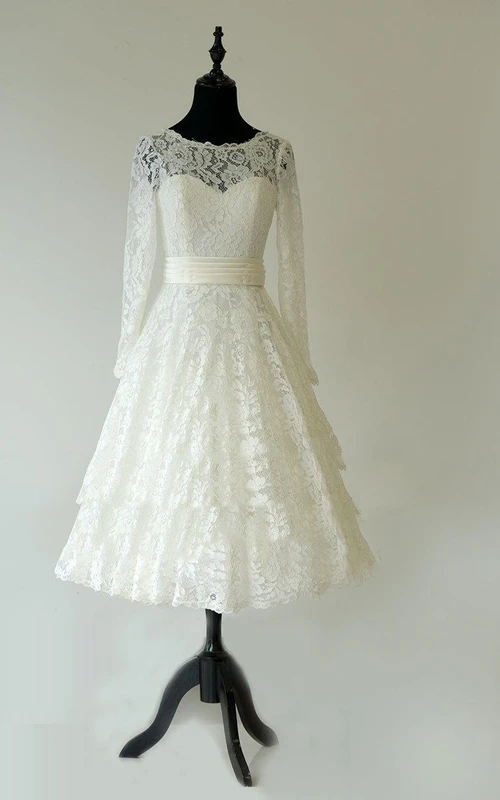Vestido largo de encaje con escote barco y manga larga, largo hasta la rodilla, con fajín.