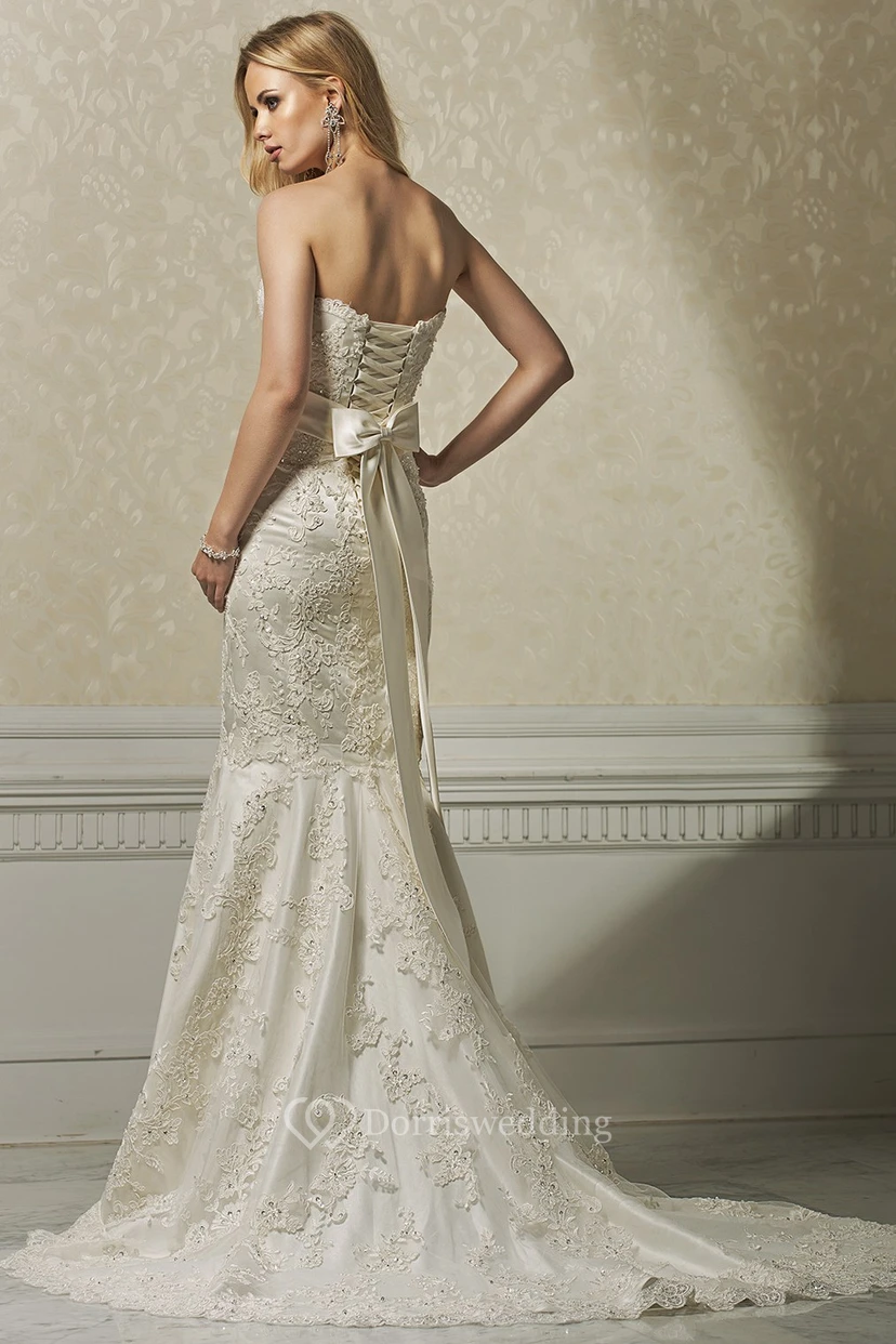 Langes, ärmelloses Brautkleid mit Trompetenapplikationen, herzförmigem Dekolleté und Spitze, dazu passender Taillenschmuck view 2