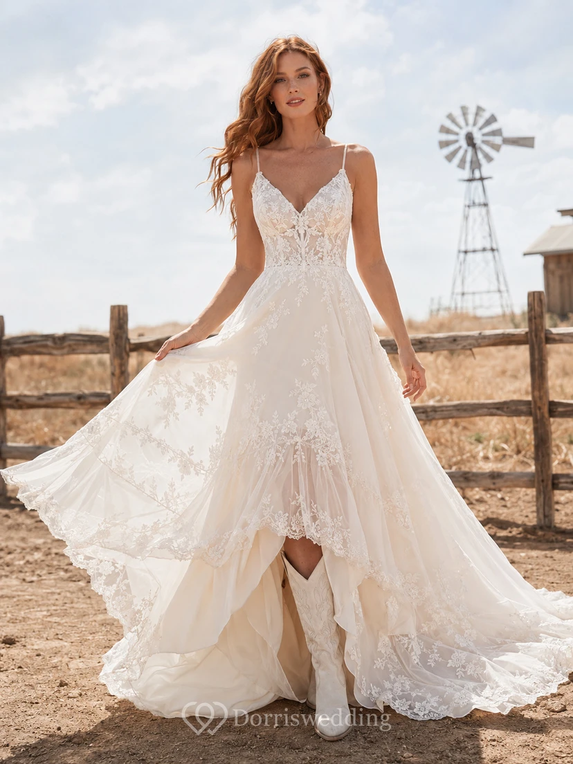 Robe de mariée champêtre en tulle et dentelle, coupe trapèze, bretelles spaghetti, traîne chapelle et dos nu plongeant en V.