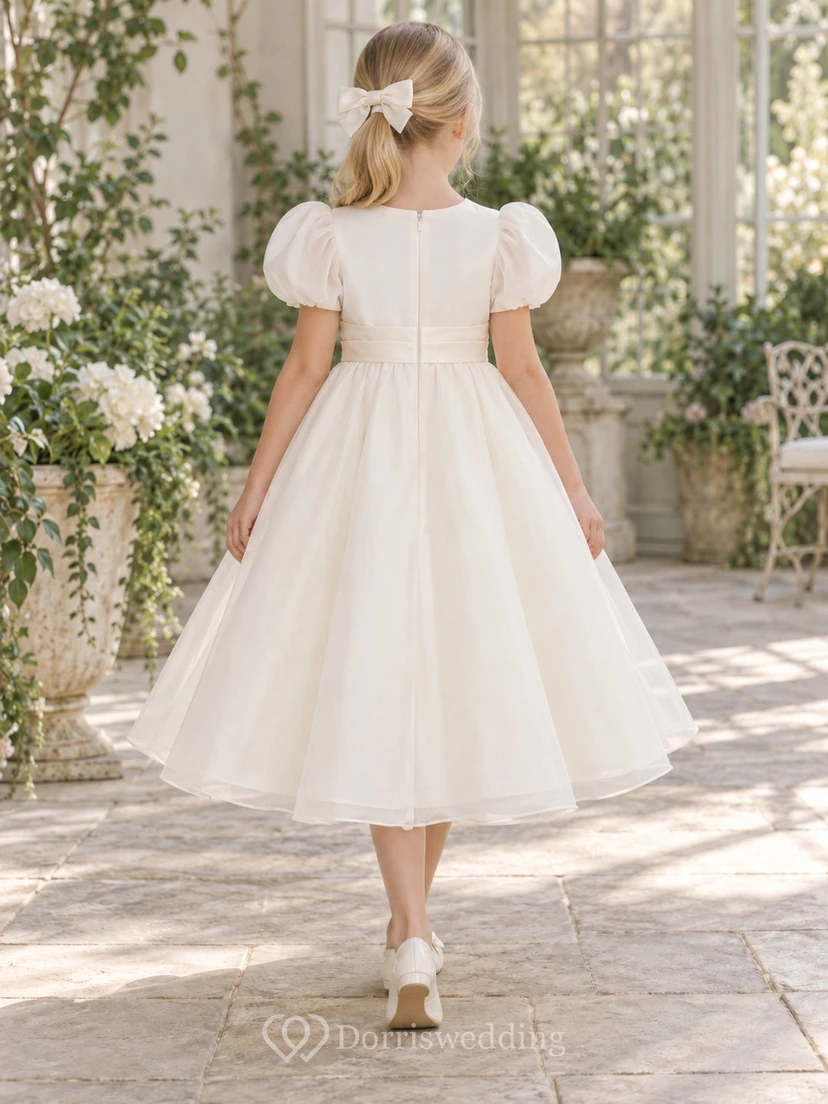 Schlichtes elfenbeinfarbenes, teelanges Organza-Blumenmädchenkleid mit abgerundeten Puffärmeln, geschwungener Schärpe und Rosettenapplikation view 2