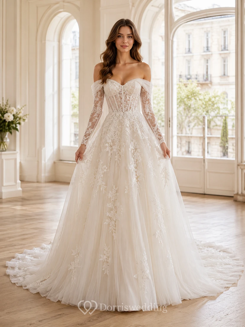Robe de mariée champêtre en tulle et dentelle fine, épaules dénudées, manches longues, coupe trapèze, traîne chapelle, ornée d'appliqués floraux.