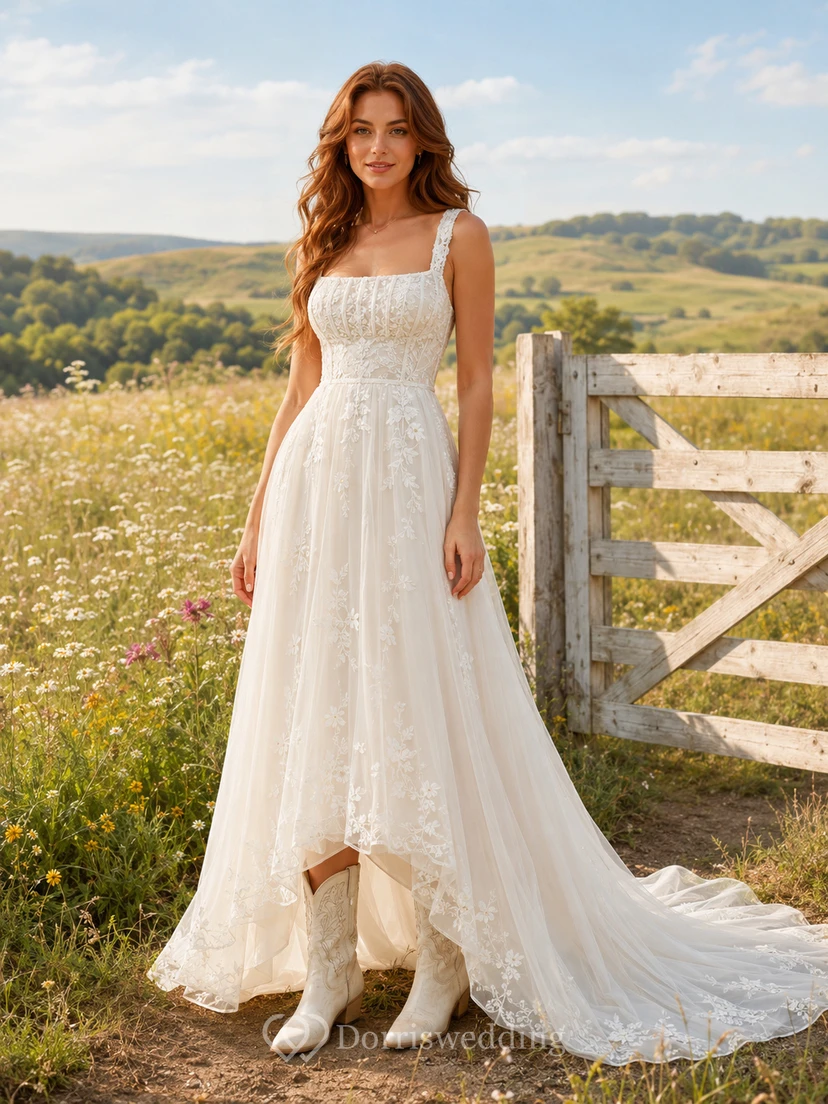 Vestido de novia de tul y encaje estilo campestre, corte en A, tirantes finos, cola capilla y escote en V bajo en la espalda.