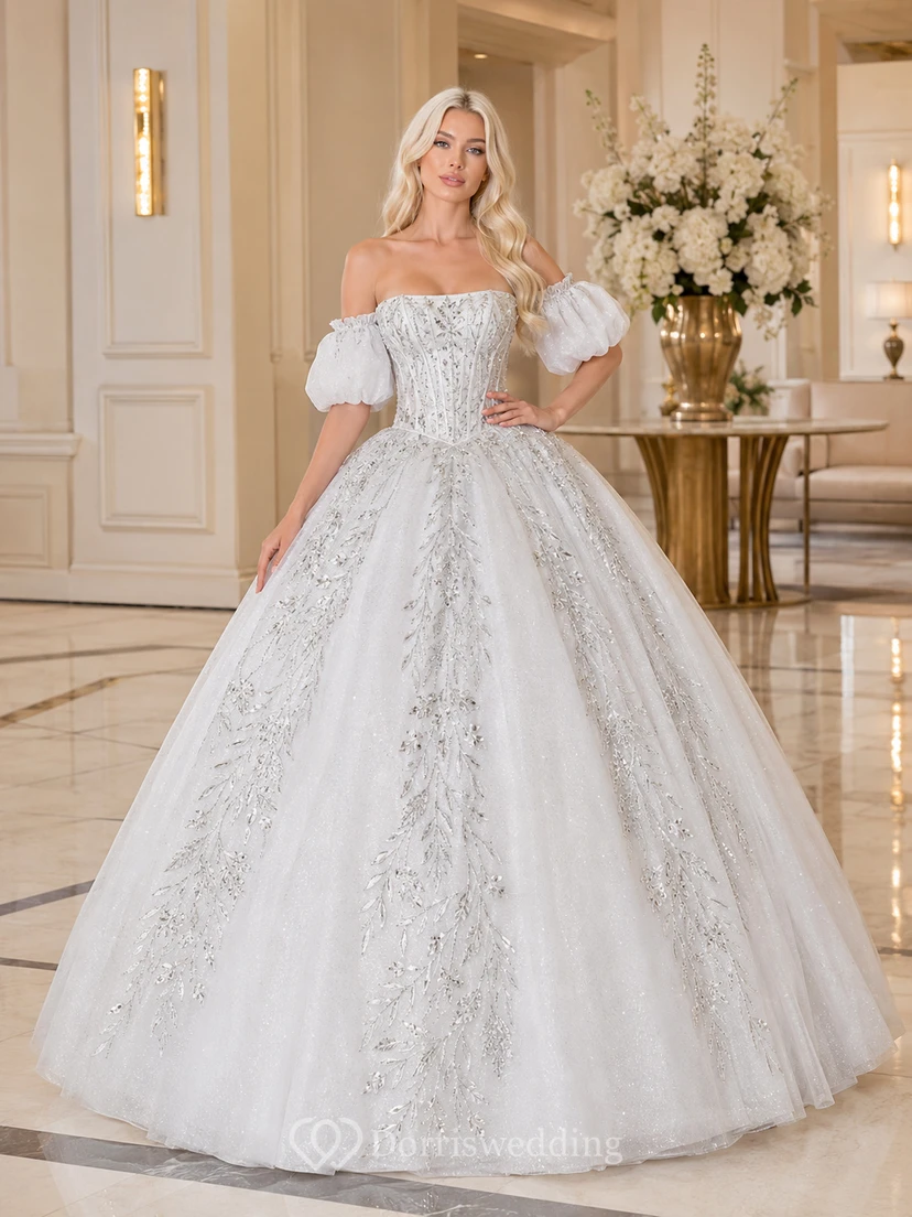 Vestido de fiesta de quinceañera de lujo, blanco y plateado, con hombros descubiertos, mangas abullonadas y bordados.
