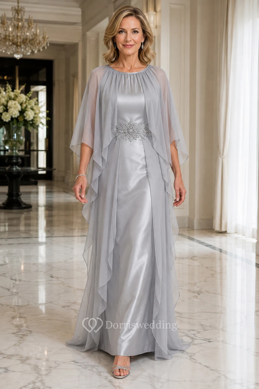 Vestido largo hasta el suelo de satén plateado y gasa con mangas tipo capa y cuello joya, ideal para la madre de la novia.