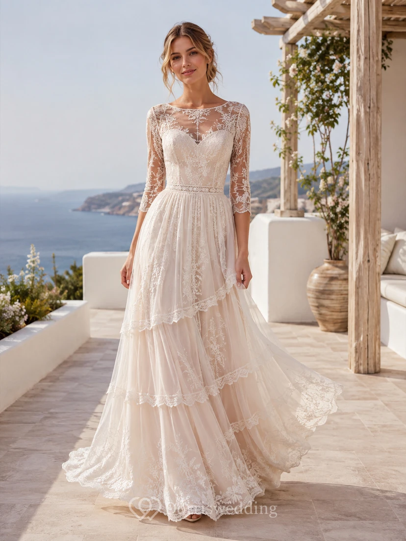 Robe de mariée longue à traîne, décolleté bateau, manches longues, dentelle illusion, tulle, volants, coupe trapèze, longueur au sol.