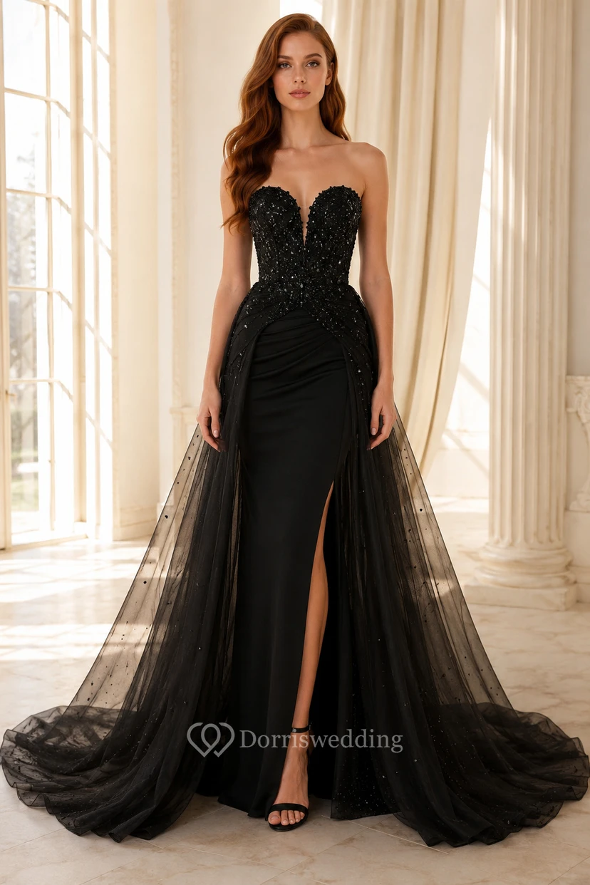 Vestido de fiesta negro sin tirantes de tul con corpiño bordado, abertura alta y cola.
