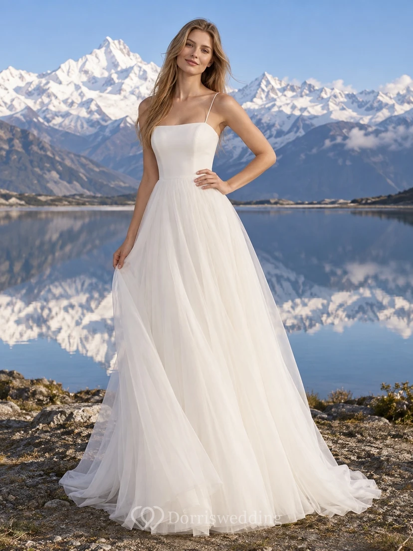 Vestido de novia sencillo de tul con tirantes finos, escote cuadrado y corte en A, con cola.