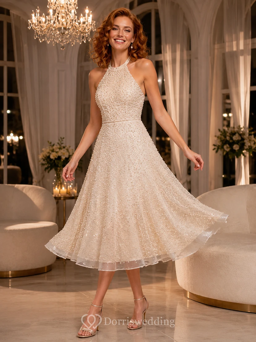 Robe de mariée champagne à col halter et coupe trapèze, longueur thé, ornée de perles, idéale pour une réception.