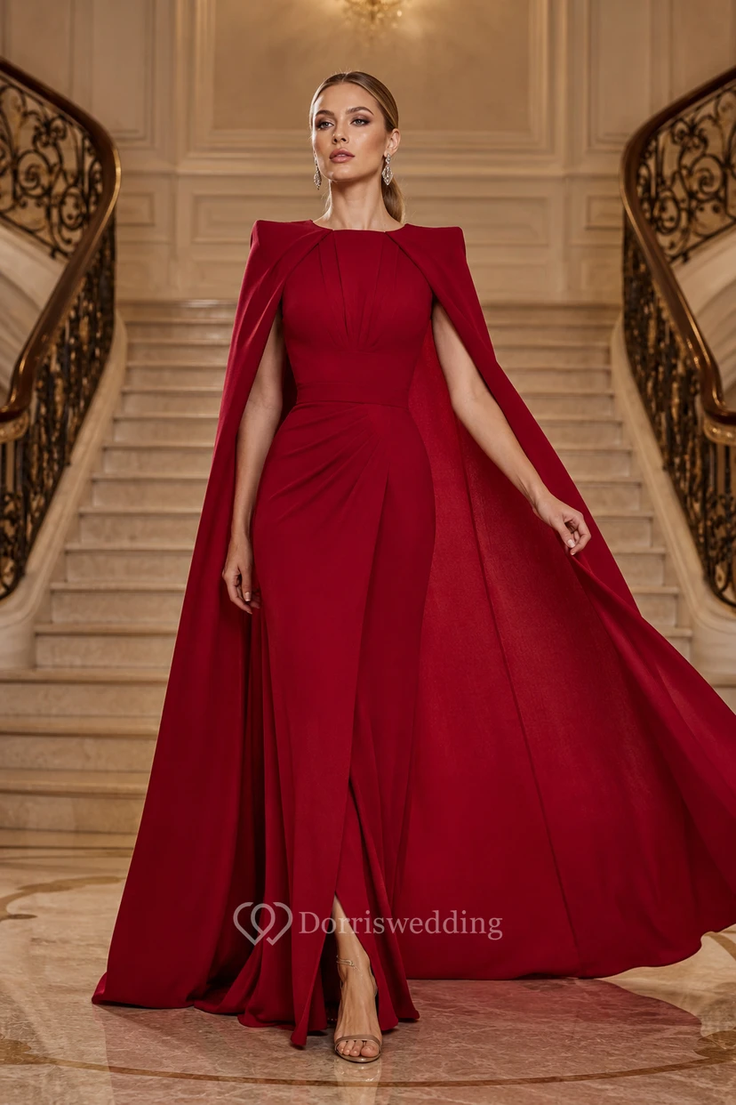 Vestido de noche rojo de corte A con mangas tipo capa, escote barco y falda larga con abertura frontal.