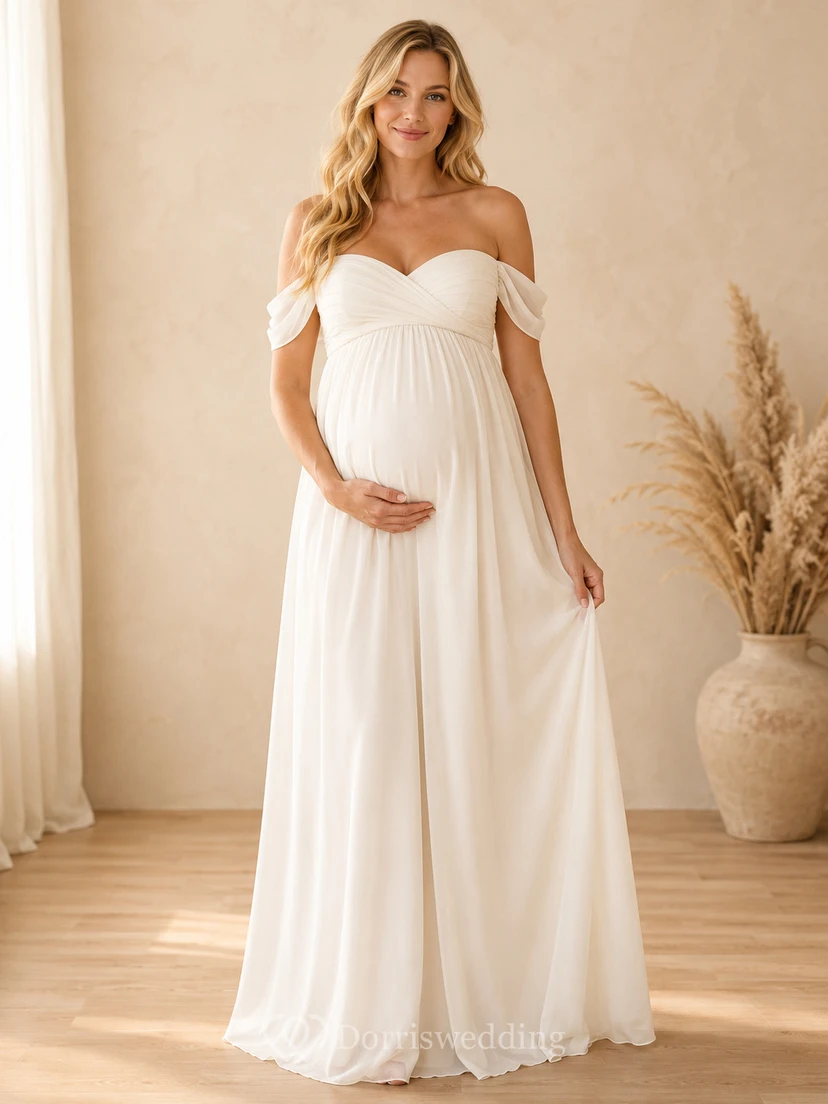Klassisches, weißes Umstandskleid im Empire-Stil mit bodenlangem Schnitt, schulterfrei und kurzen Ärmeln aus Chiffon – romantisch und elegant – perfekt für Brautjungfern und Gäste im Garten.
