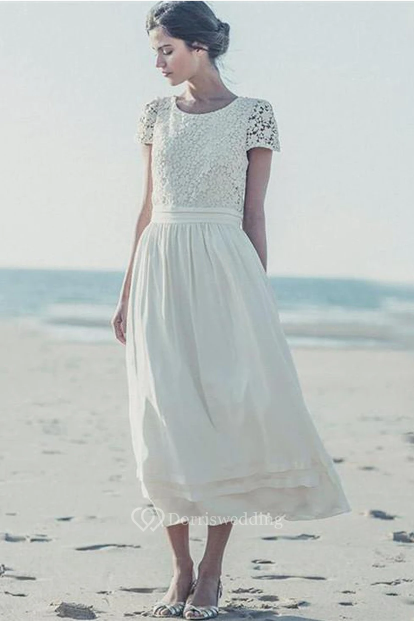 Robe de mariée blanche en dentelle, coupe trapèze, manches courtes, longueur thé, ornée de bijoux. video preview