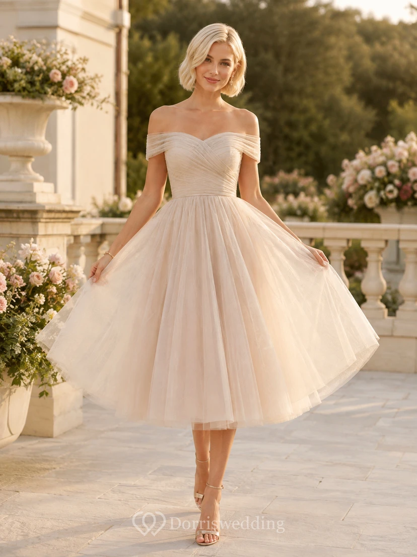 Vestido de invitada de boda romántico de tul color marfil con hombros descubiertos y mangas cortas, corte en A y largo hasta la rodilla.