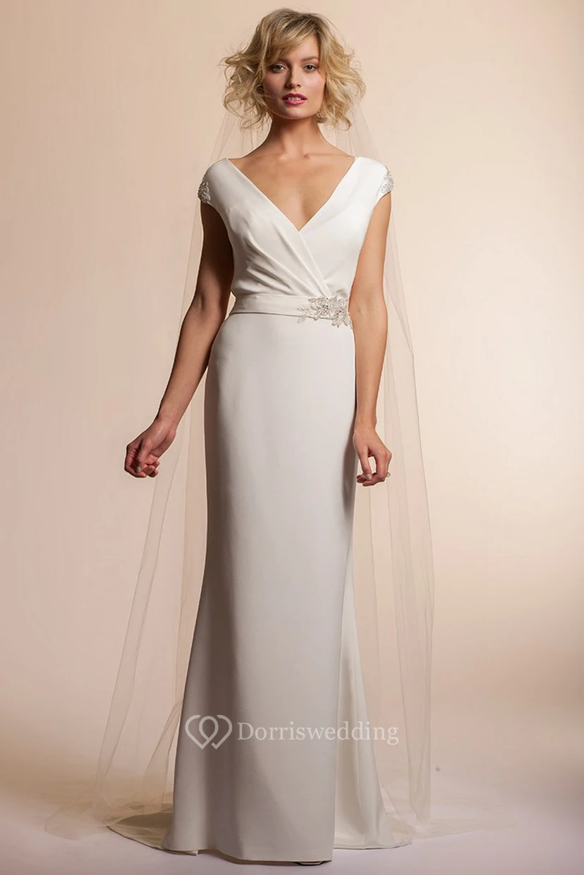 Vestido de novia sencillo de gasa con escote en V, mangas cortas y detalles de pedrería, largo hasta el suelo.