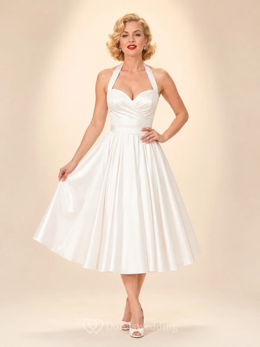 Robe d'invitée élégante vintage en mousseline blanche, dos nu, sans manches, coupe trapèze, longueur thé, plissée, style vintage.