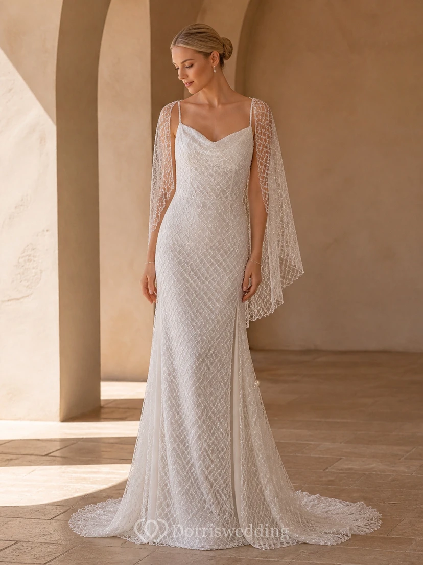 Vestido de novia bohemio de corte recto con mangas murciélago y escote drapeado, encaje geométrico y falda larga.