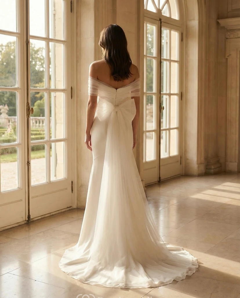 Schulterfreies Brautkleid mit übergroßer Schleife am Rücken und weicher Tüllschleppe view 2