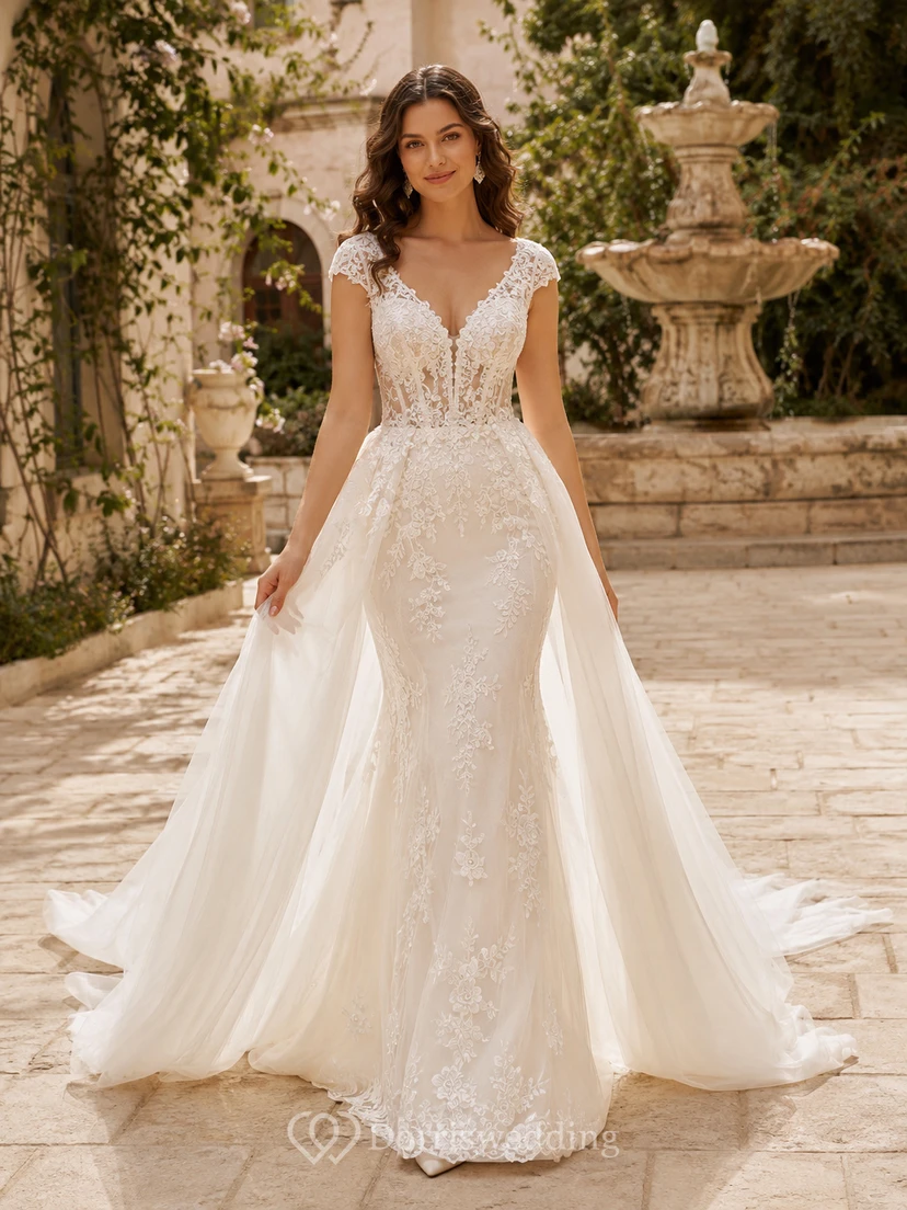 Robe de mariée romantique en dentelle et tulle, décolleté plongeant en V, coupe trapèze, ornée d'appliques et d'un dos nu.