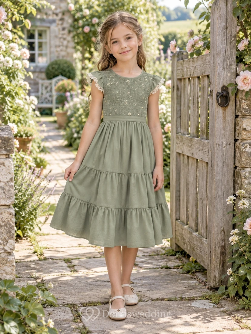 Vestido de niña de flores de corte A, manga corta, corpiño de lunares y volantes, color verde salvia, largo hasta la rodilla, con lazo en la espalda.