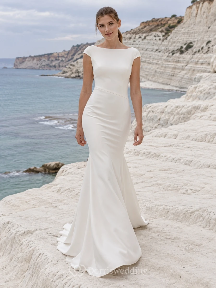 Vestido de novia sencillo de sirena con escote barco, manga corta, espalda de satén y cola de crepé.