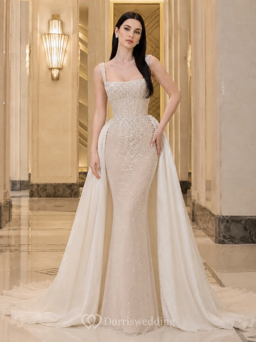 Robe de mariée fourreau sans manches en satin et dentelle immaculés, col carré, traîne chapelle, surjupe amovible, idéale pour une salle de bal.