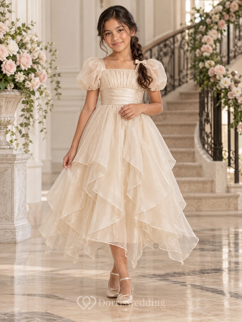 Teelanges, eckiges Ausschnittkleid aus elfenbeinfarbenem Organza in A-Linie mit Puffärmeln, plissiertem Oberteil und asymmetrischem Schnitt – ideal für Blumenmädchen.