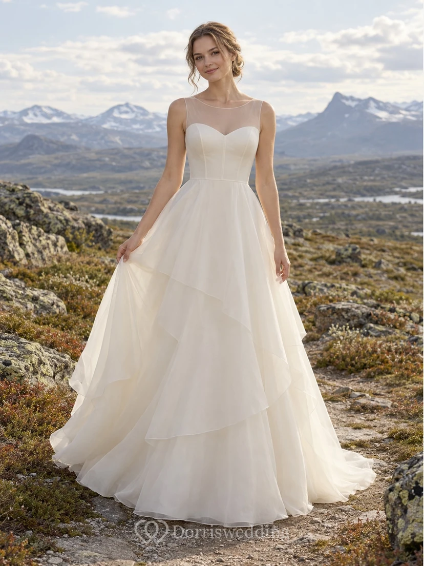 Vestido de novia de organza sin mangas con cuello alto, corte en A, canesú ilusión y falda de capas.