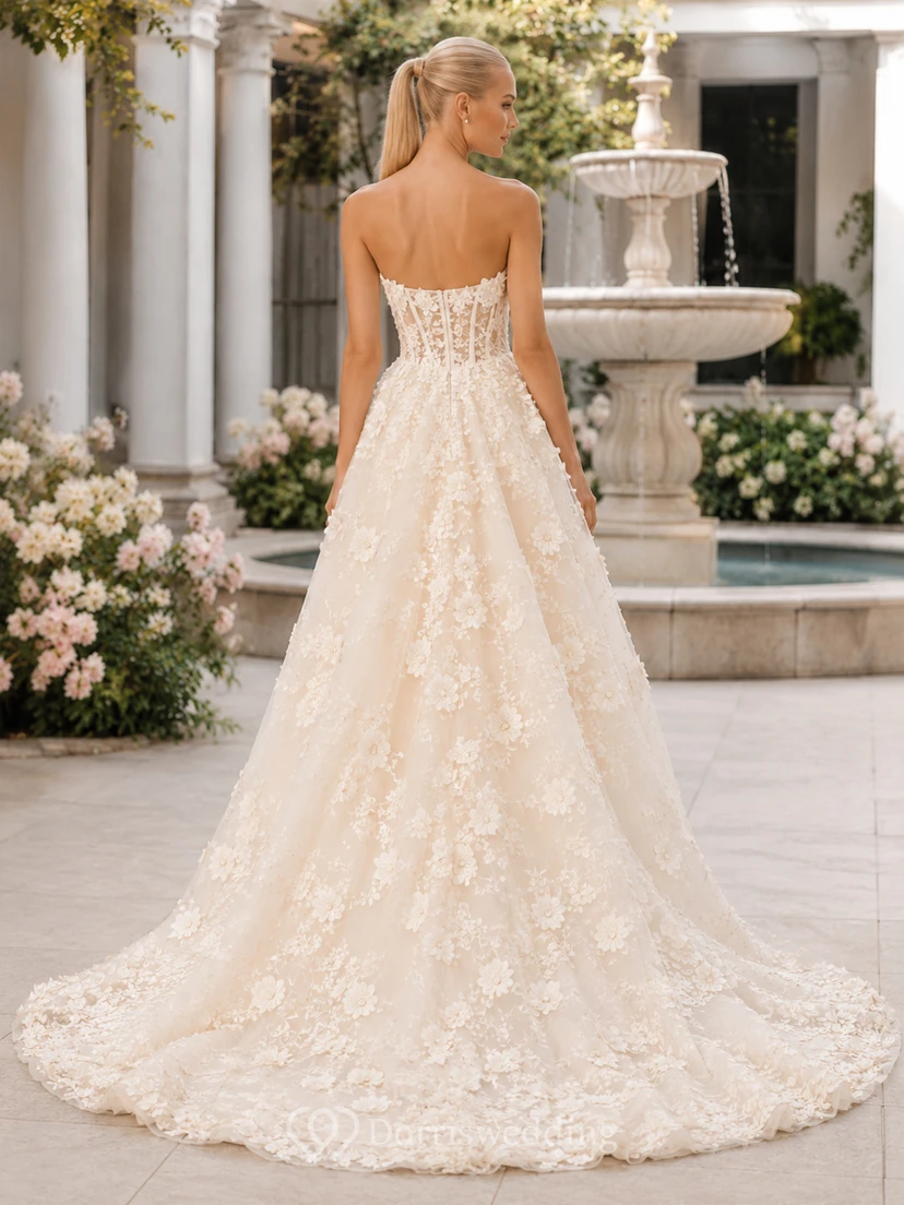 Vestido de novia asimétrico sin tirantes con apliques florales y corte en el patio. view 2