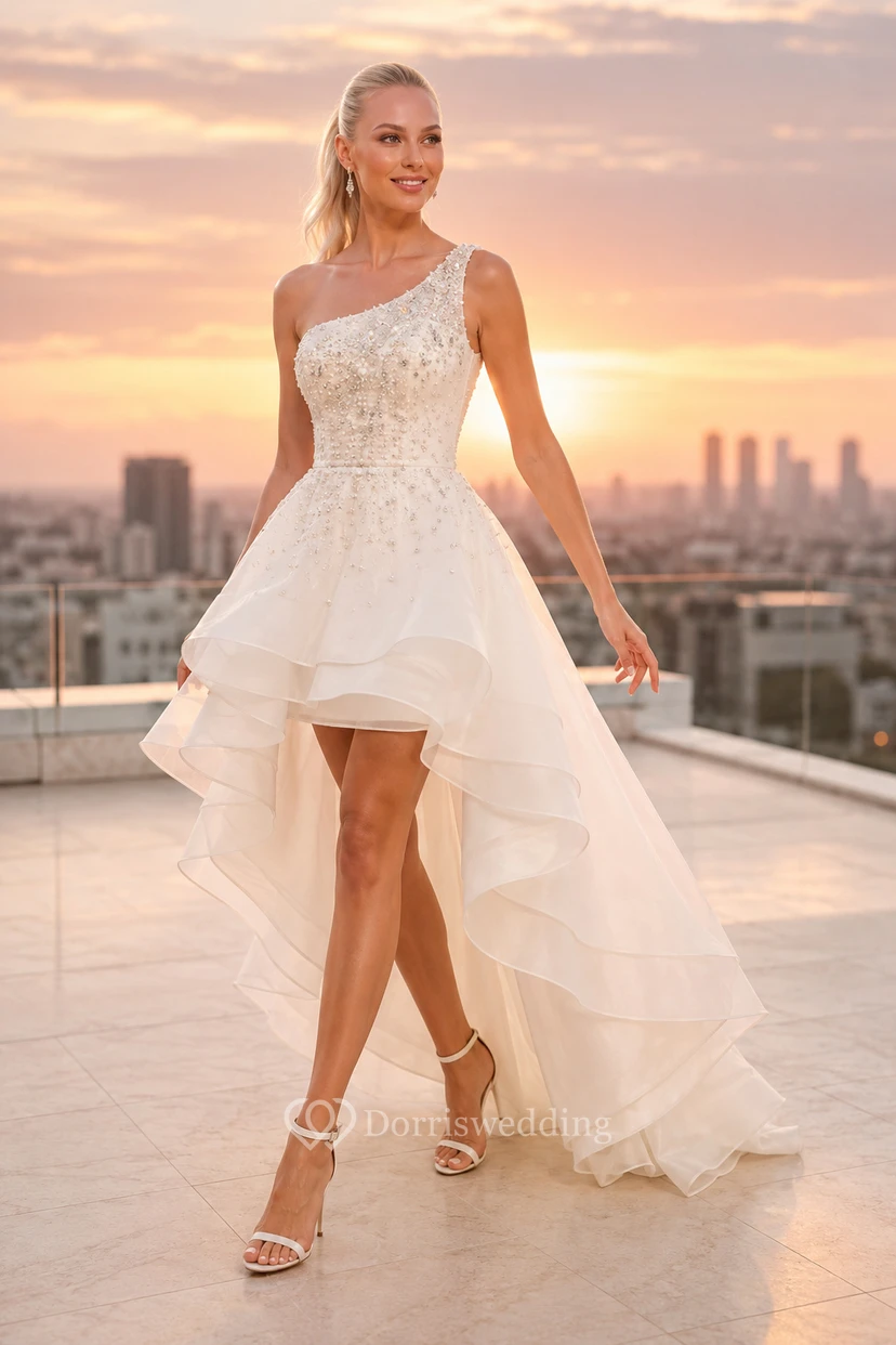 Robe de mariée asymétrique en dentelle avec traîne en tulle et épaule dénudée.