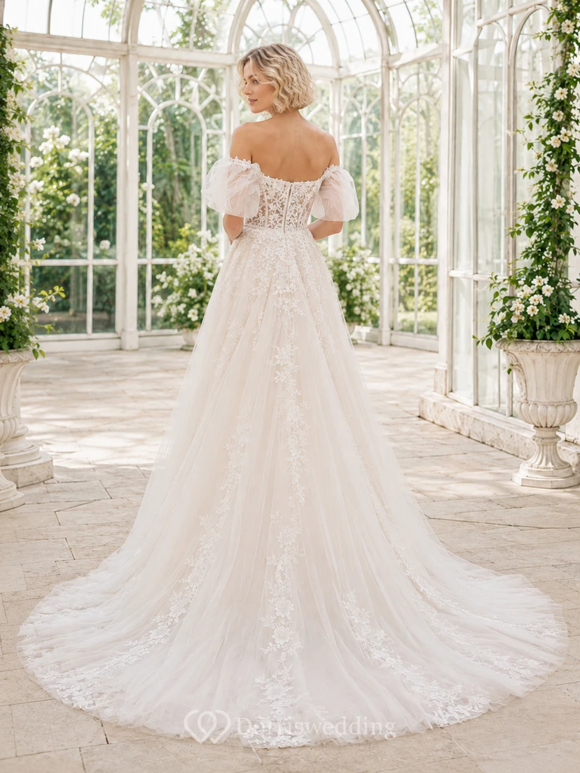 Robe de mariée élégante en dentelle et tulle, épaules dénudées, manches courtes, coupe trapèze, traîne chapelle, ornée d'appliqués floraux, au bord d'un lac view 2