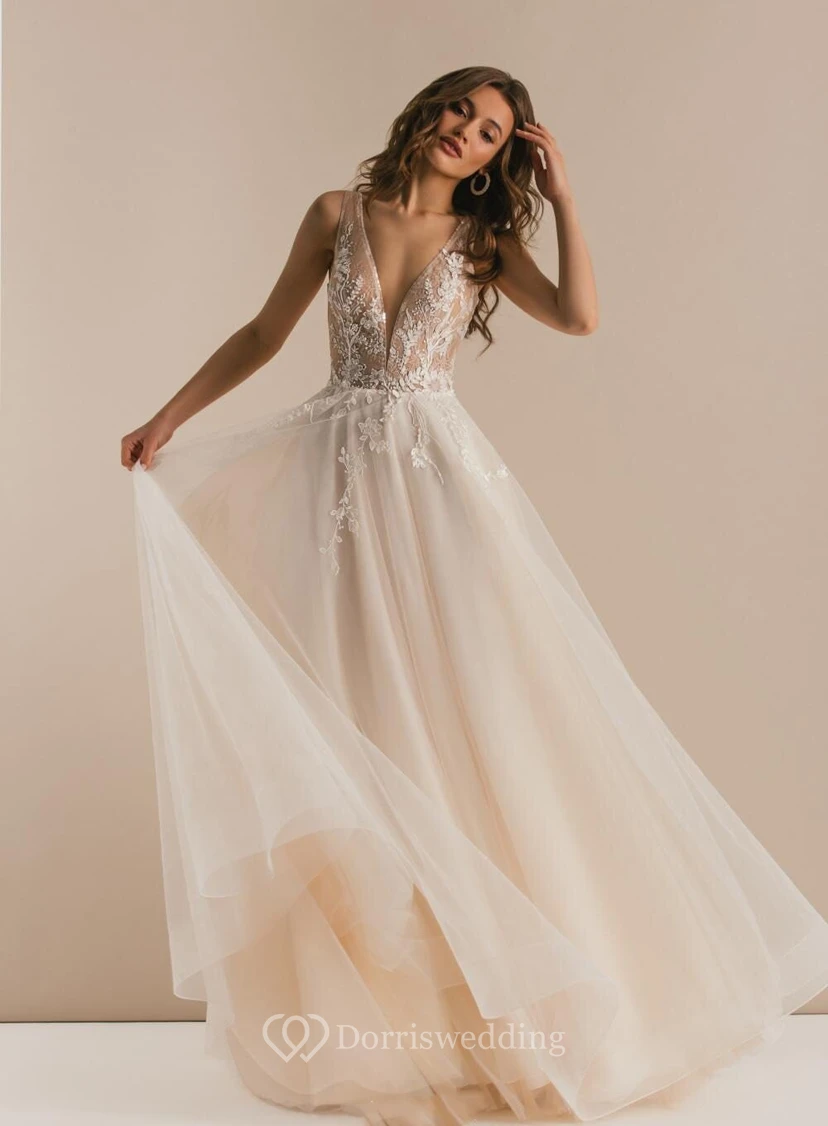 Robe de mariée vaporeuse et sexy en tulle, décolleté en V, sans manches, coupe trapèze, en tulle.
