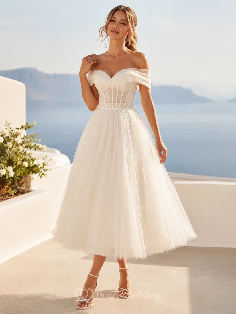 Vestido de novia romántico de tul con corsé y hombros descubiertos, largo hasta la rodilla, para una boda en la playa.