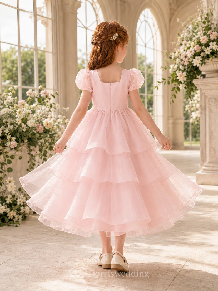 Robe de demoiselle d'honneur en organza rose poudré, coupe trapèze, manches courtes, col rond, jupe mi-longue, détails à volants view 2