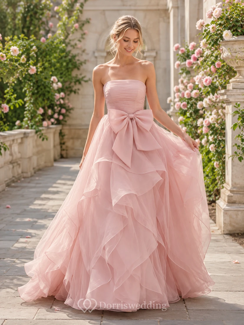 Robe de mariée bustier rose poudré à volants en tulle et nœud cascade