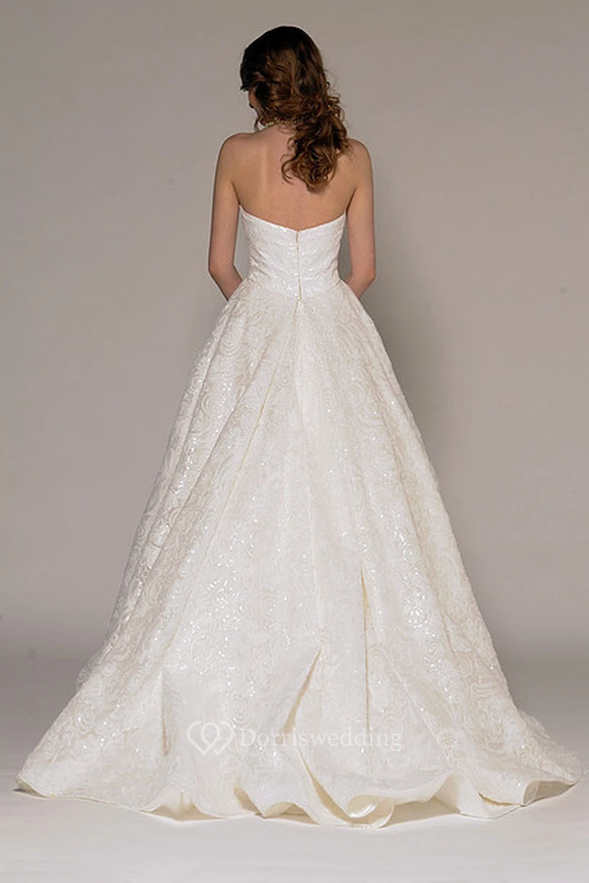 Vestido de novia asimétrico sin tirantes con encaje y pedrería en la espalda en V. view 2
