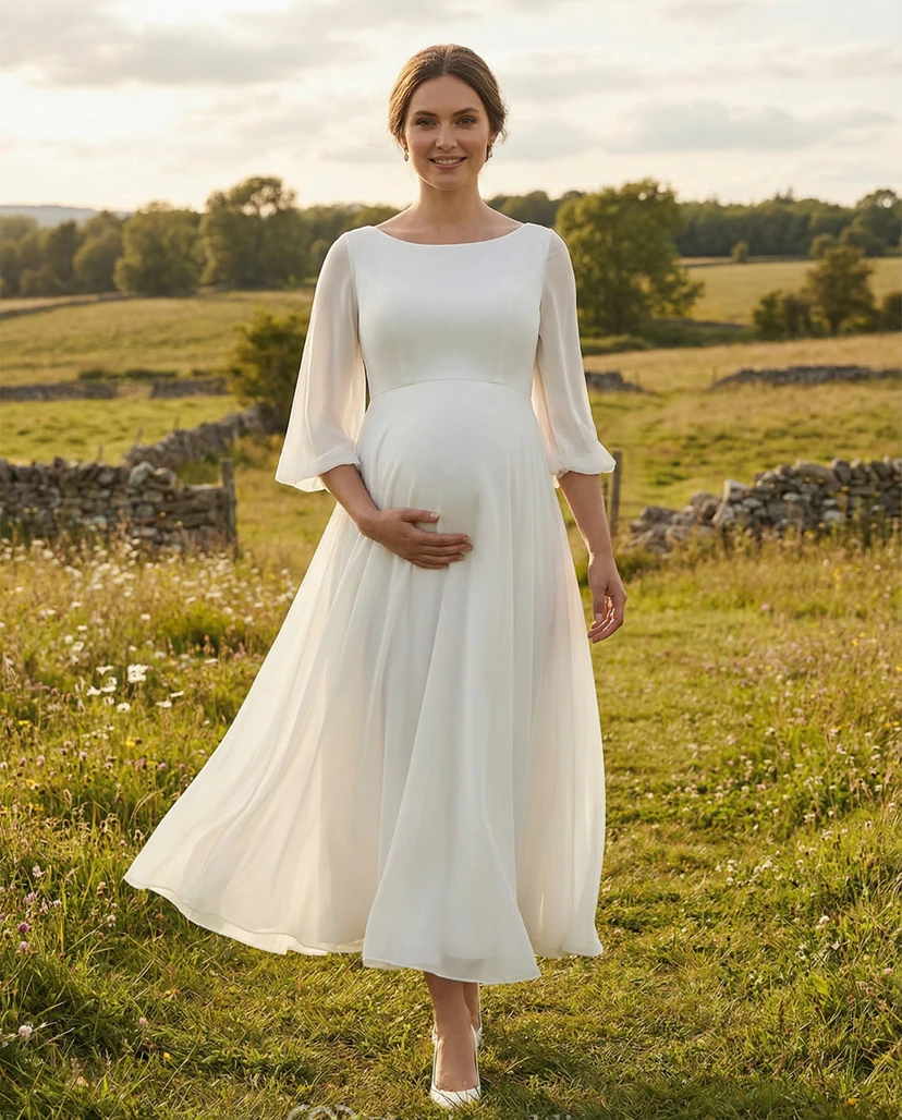 Robe de mariée de maternité à encolure bateau, manches papillon transparentes et jupe mi-longue.