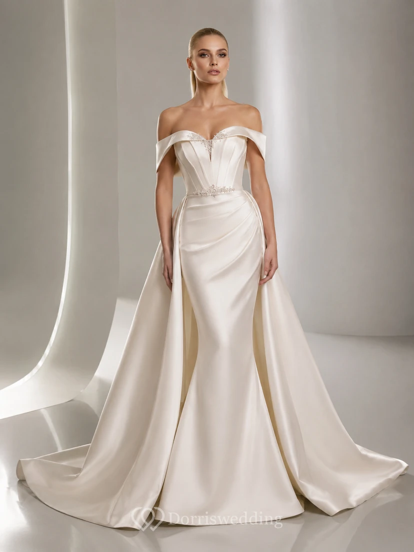 Robe de mariée sirène en satin radieux, épaules dénudées, manches courtes, traîne et jupe amovible.