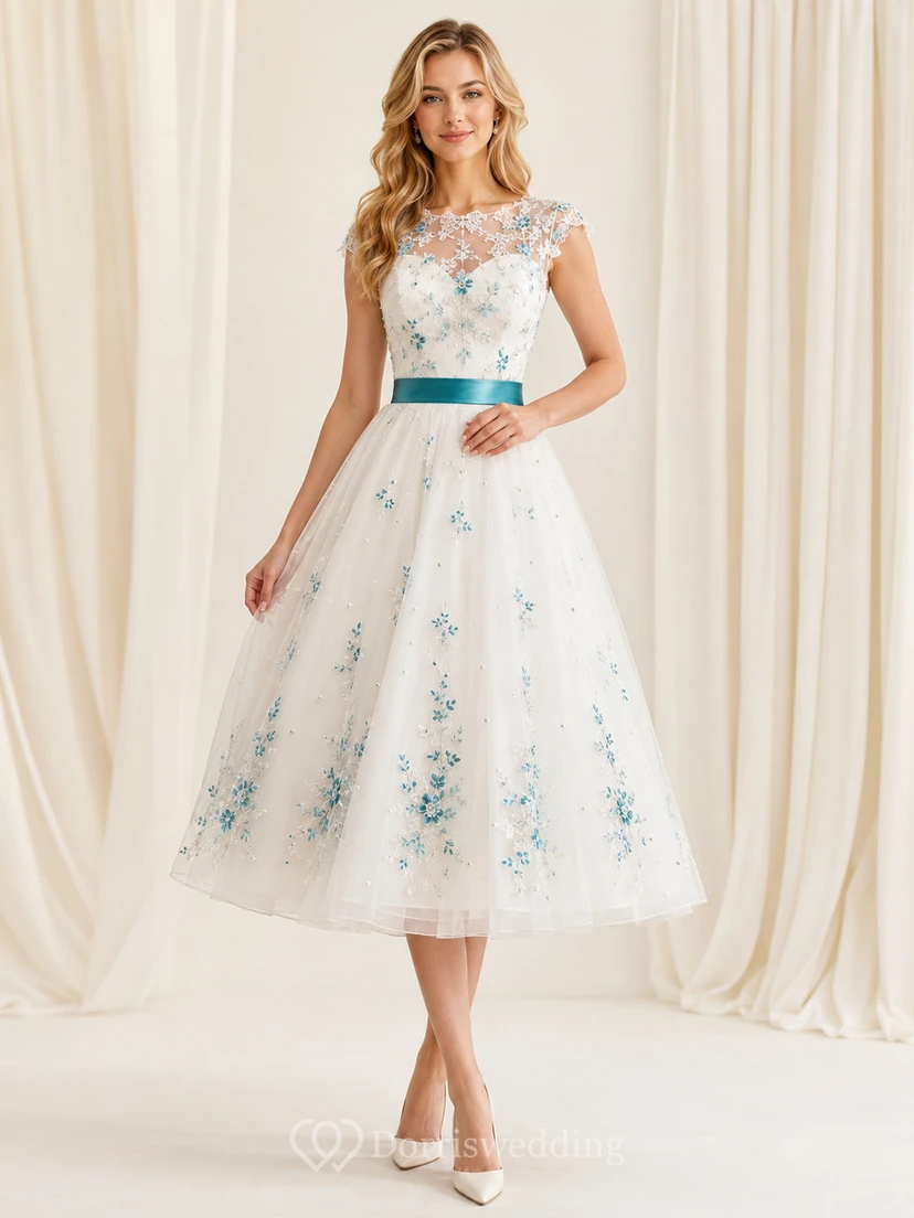 Vestido de novia de tul de corte A con escote barco y mangas cortas, largo hasta la rodilla, estampado floral en color verde azulado.
