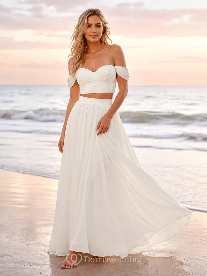 Conjunto nupcial para playa con falda de gasa fruncida y hombros descubiertos al atardecer.